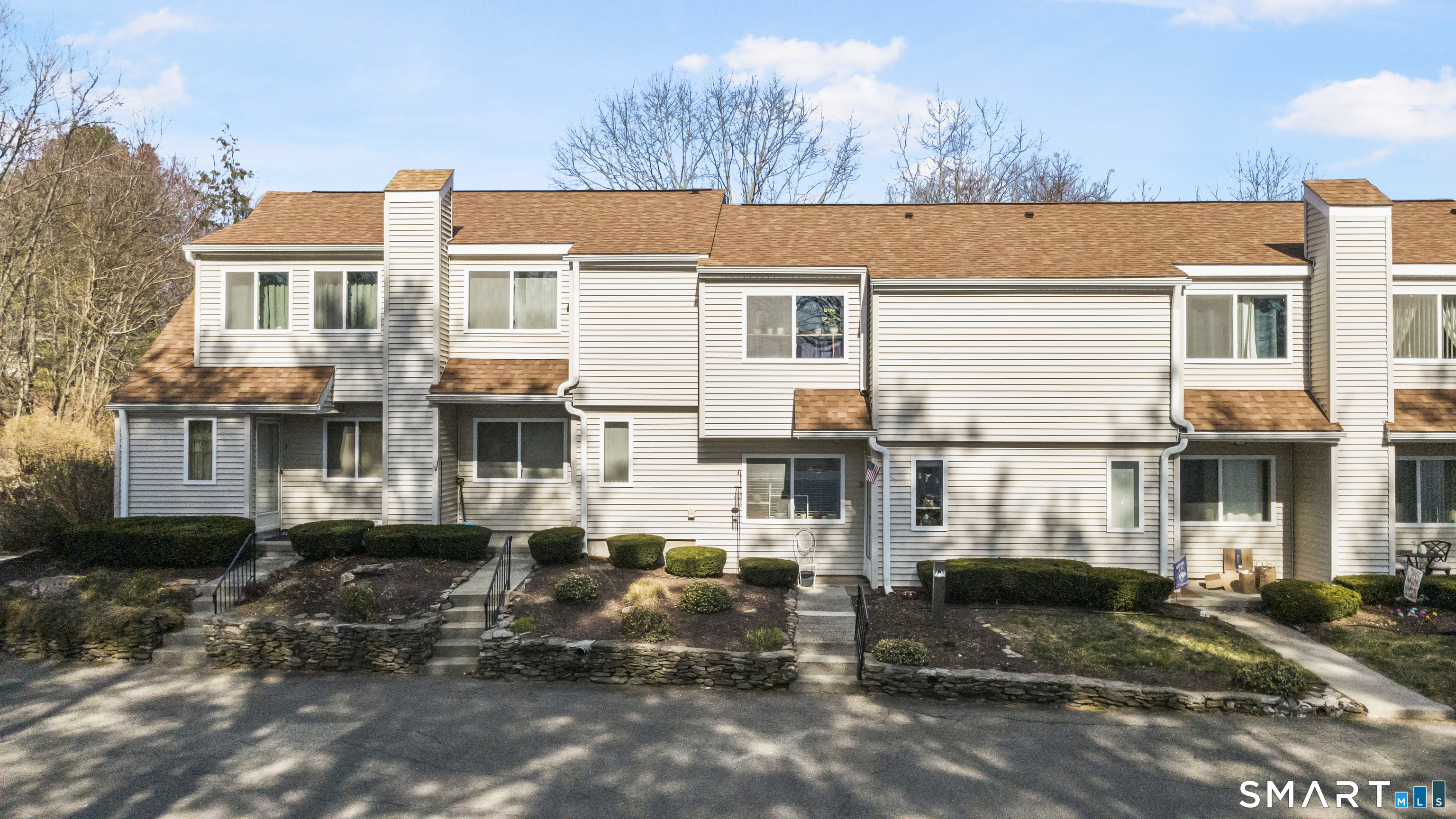 3 MacIntosh Lane, Unit 3 Ansonia, CT 06401 - Photo 8 of 34 a view of a blue house with large windows and a table and chairs in front of it