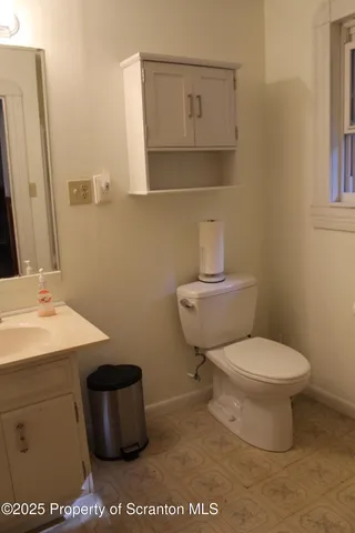 a bathroom with a toilet a sink and mirror