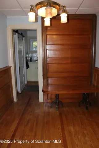 a view of a hallway with wooden floor and closet