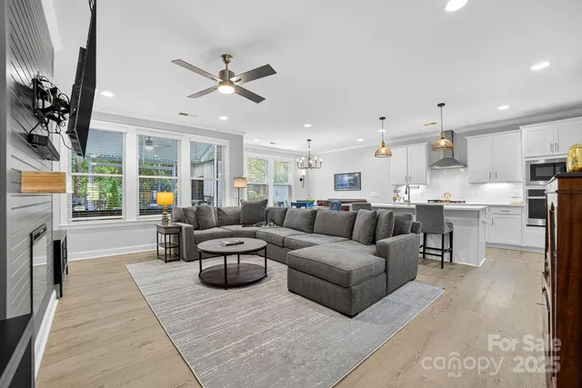 a living room with furniture a fireplace and a large window with garden view
