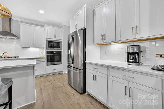 a kitchen with stainless steel appliances a refrigerator sink and microwave