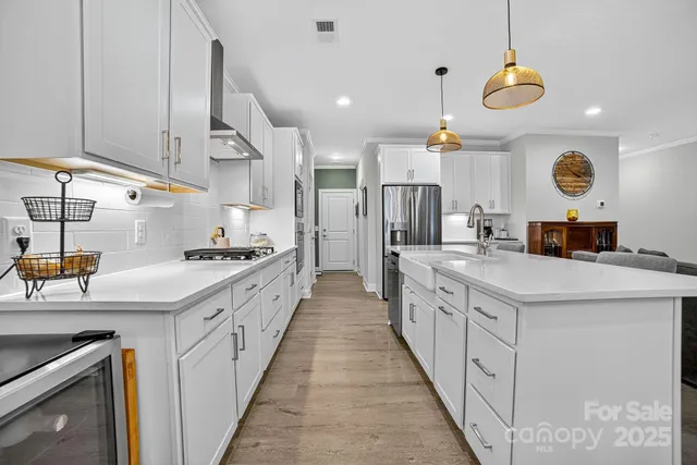 a kitchen with a stove a window cabinets and dining table