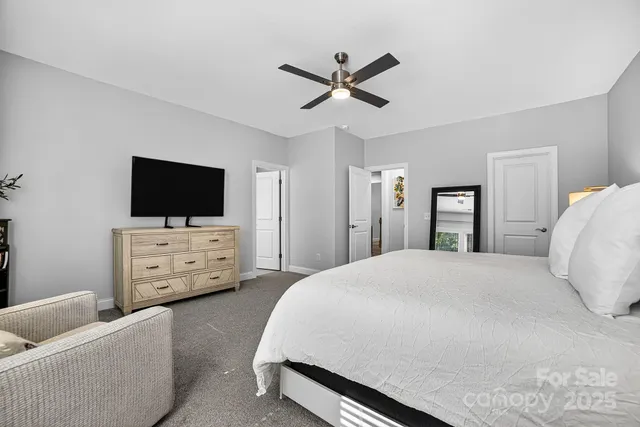 a spacious bedroom with a bed and a flat screen tv