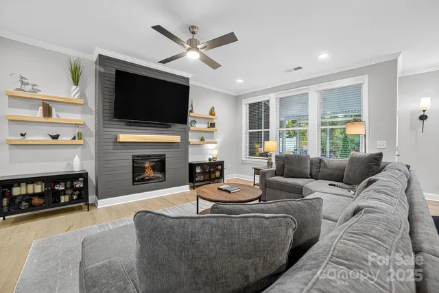 a living room with furniture a flat screen tv and a fireplace