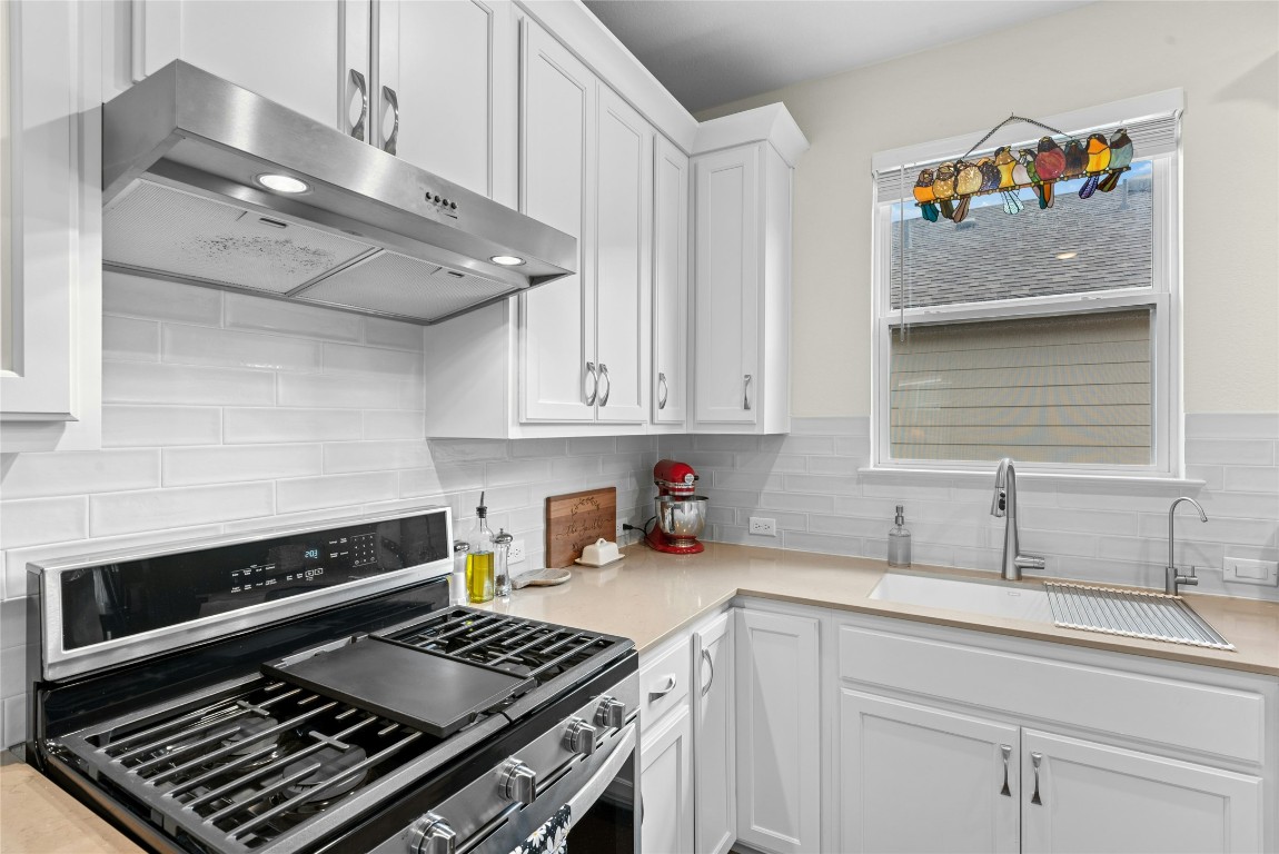 104 Coachsmith Street Georgetown, TX 78633 - Photo 13 of 38 a kitchen with stainless steel appliances a sink stove and cabinets
