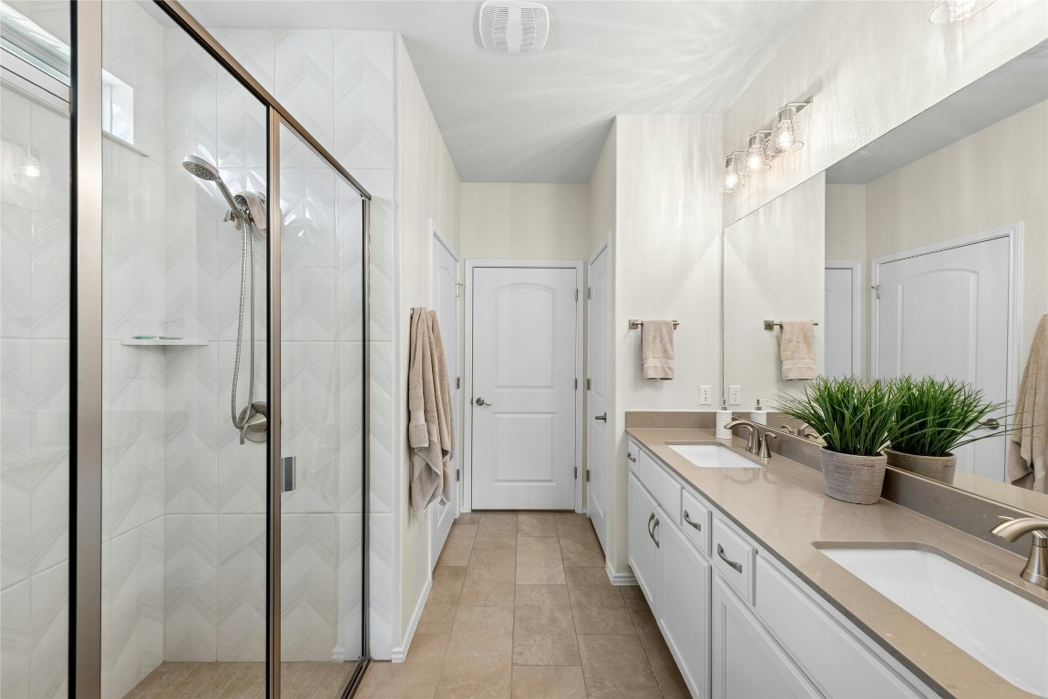 104 Coachsmith Street Georgetown, TX 78633 - Photo 18 of 38 a spacious bathroom with a double vanity sink a large mirror and a shower