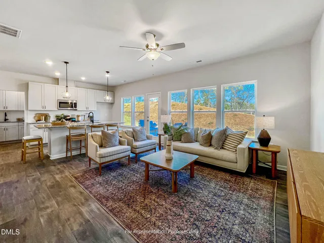 a large room with kitchen island a sink a stove and a wooden floors