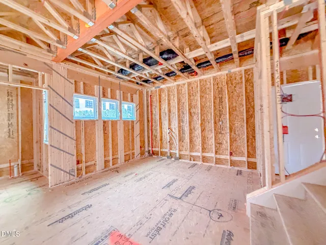 a view of a bedroom with wooden floor and chair