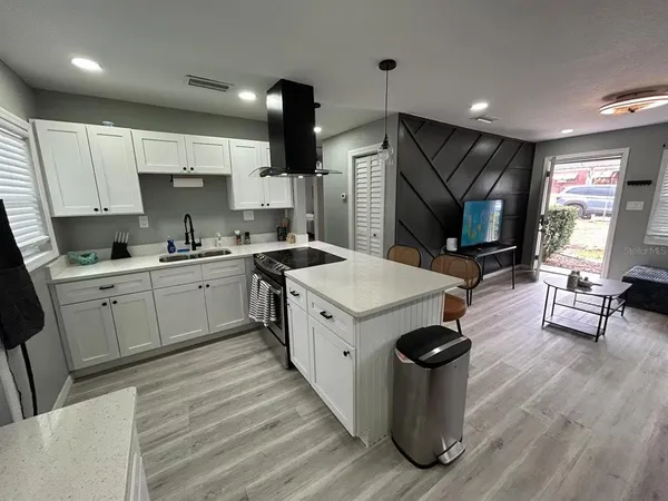 a kitchen with stainless steel appliances granite countertop sink stove refrigerator and cabinets