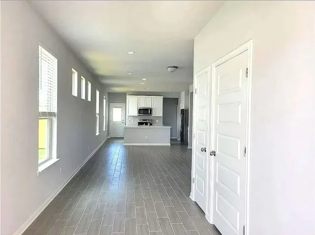 a view of a hallway view with wooden floor and windows