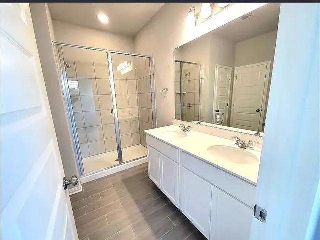 a bathroom with a granite countertop sink mirror and shower