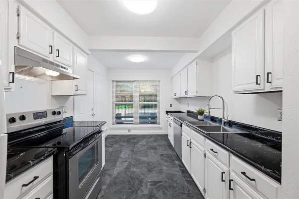 a kitchen with a sink stove top oven and cabinets