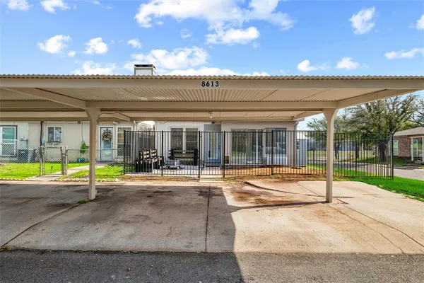 a yellow house with a large trees in front of it