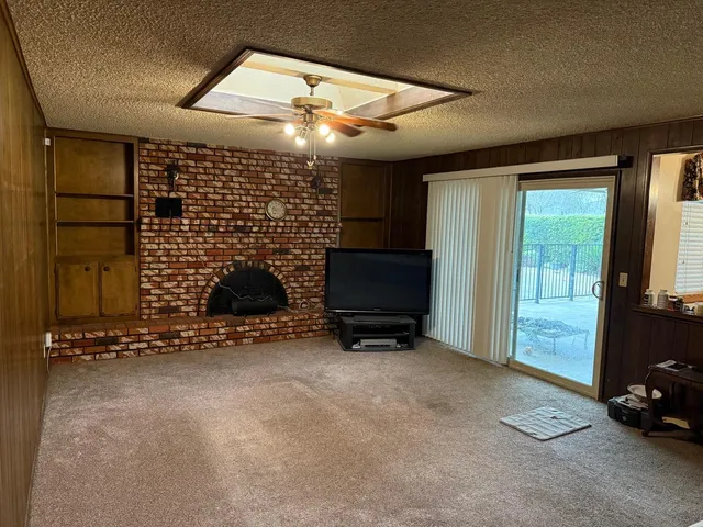 a view of empty room with windows and flat screen tv