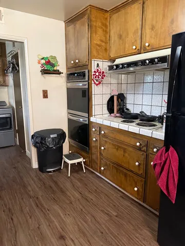 an empty room with a chandelier fan and windows