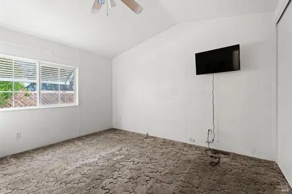 a room with a flat screen tv and a window