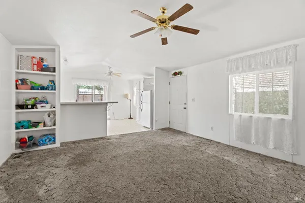 a view of an empty room with closet and a window