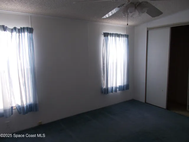 an empty room with windows and closet