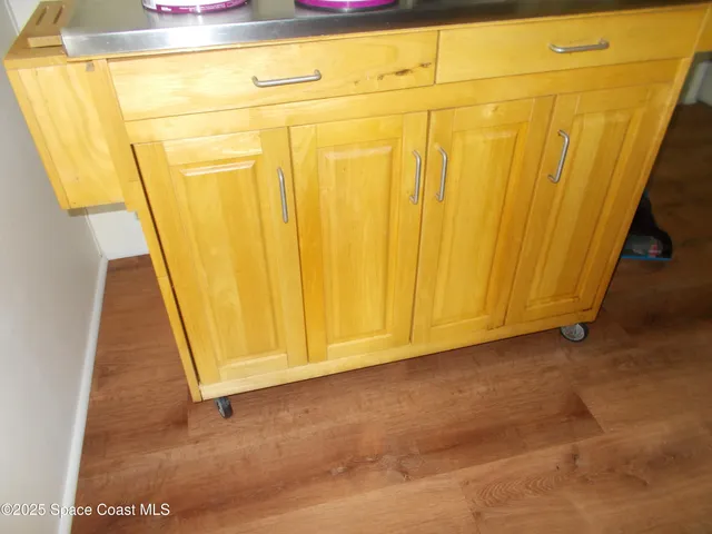 a view of a room with wooden floor and bench