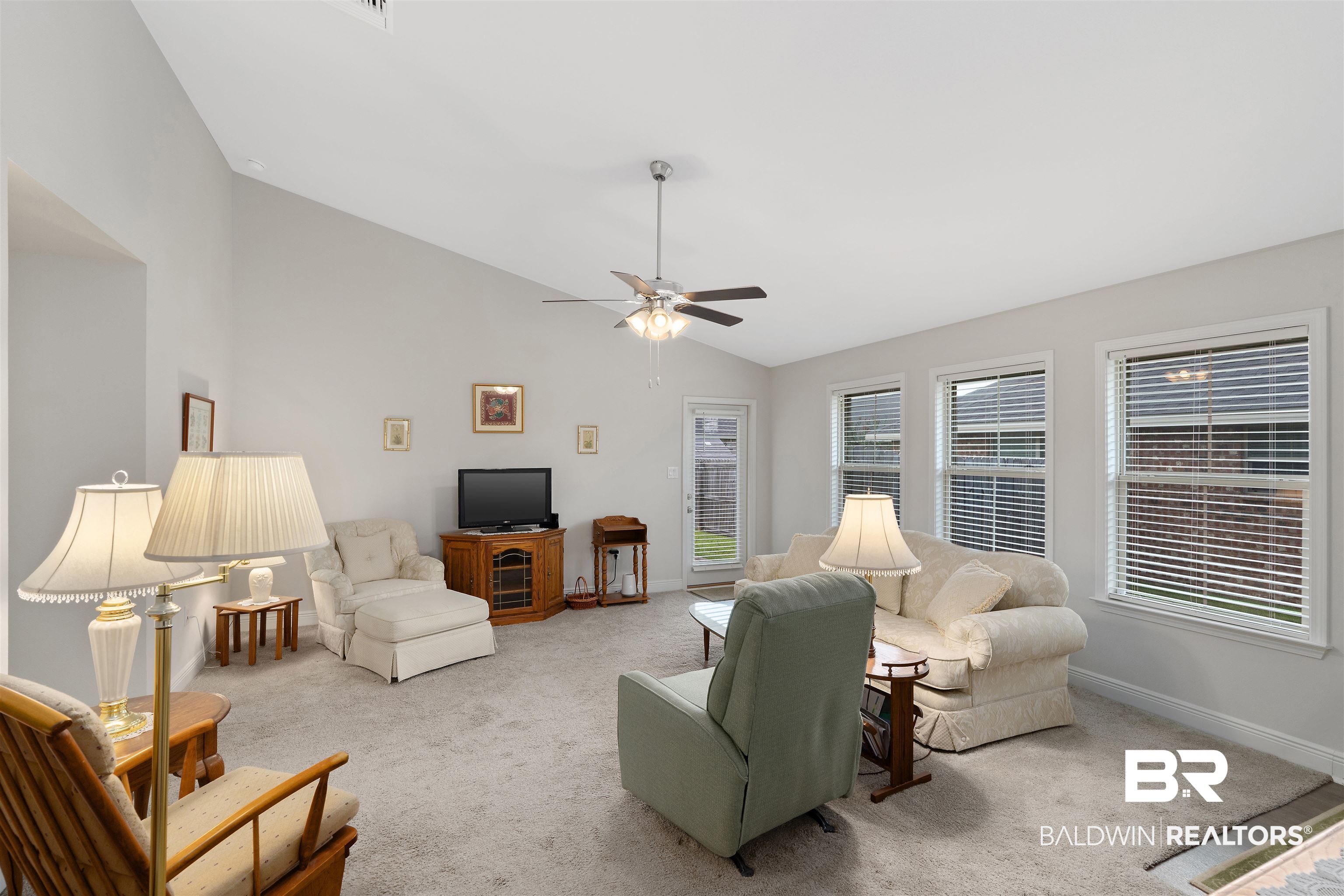 8823 Allay Lane Foley, AL 36535 - Photo 7 of 18 Carpeted living room with ceiling fan and vaulted ceiling