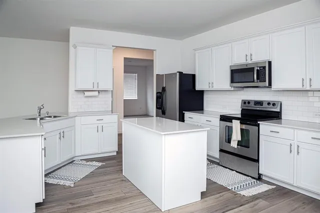 a kitchen with white cabinets and stainless steel appliances