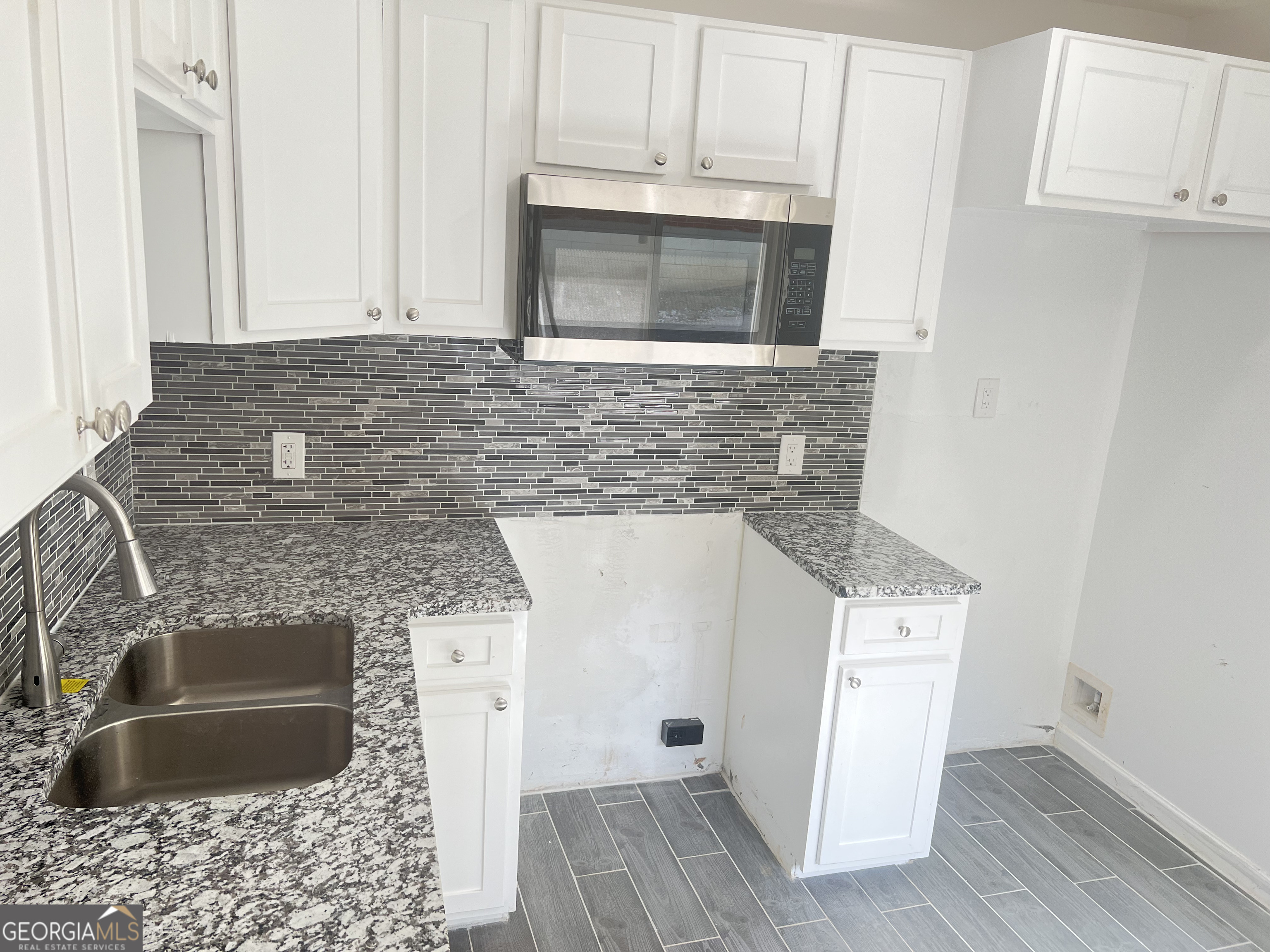 1255 Pine Avenue, Unit 2 East Point, GA 30344 - Photo 3 of 12 a kitchen with granite countertop a sink stove and microwave