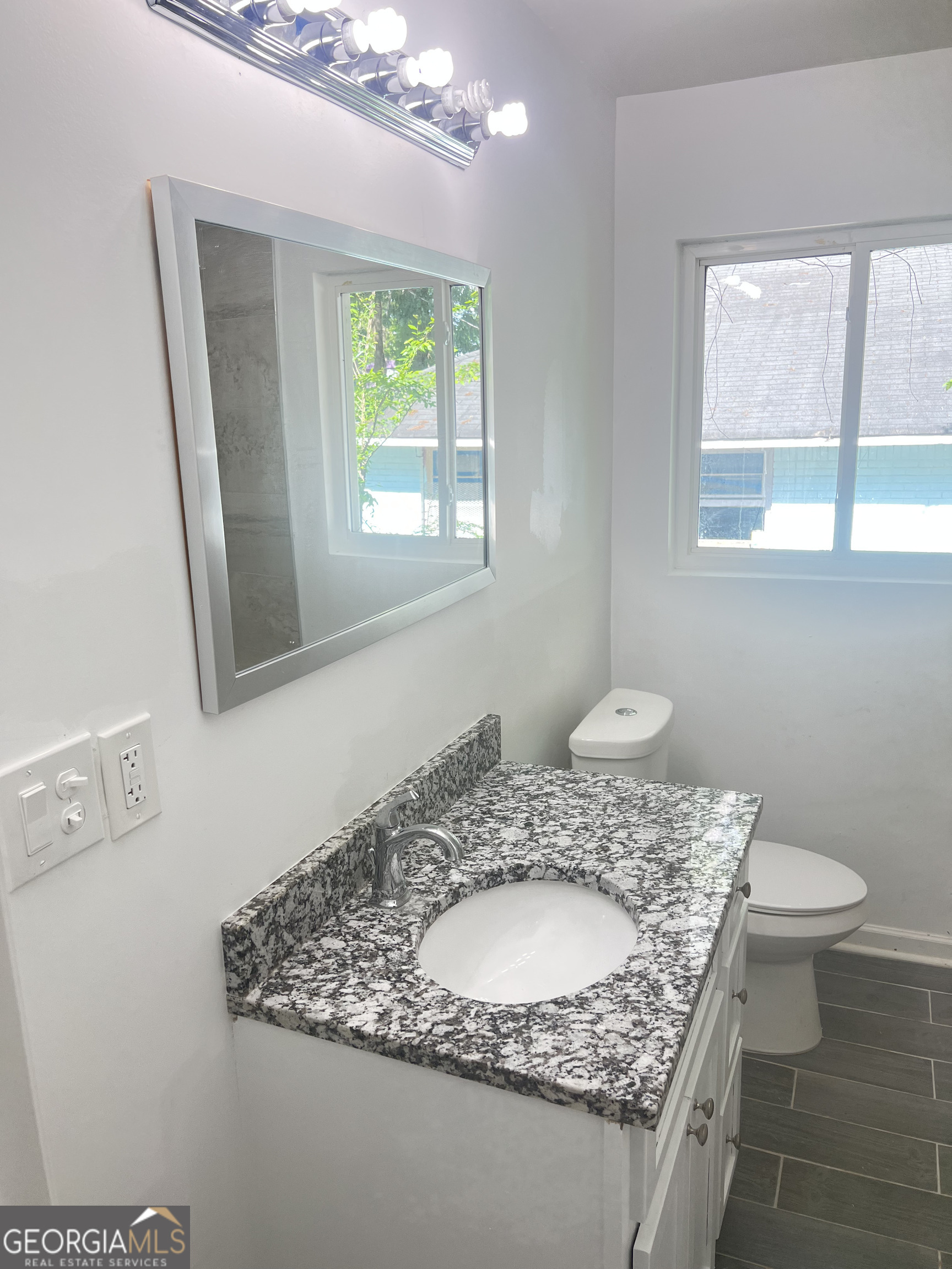 1255 Pine Avenue, Unit 2 East Point, GA 30344 - Photo 5 of 12 a bathroom with a granite countertop sink a toilet and a window