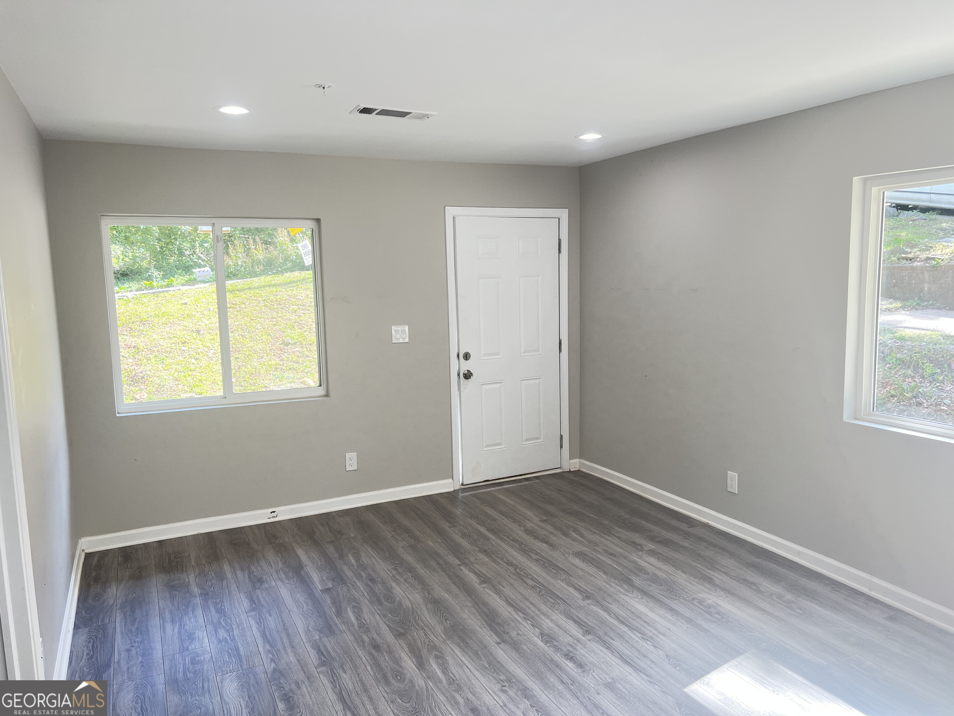 1255 Pine Avenue, Unit 2 East Point, GA 30344 - Photo 7 of 12 an empty room with wooden floor and windows