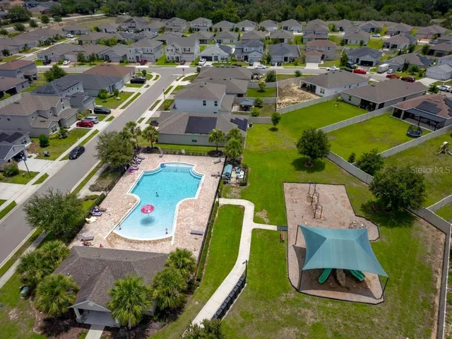 an aerial view of residential houses with outdoor space and swimming pool
