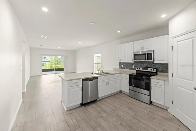 a kitchen with stainless steel appliances granite countertop a stove a sink and a refrigerator