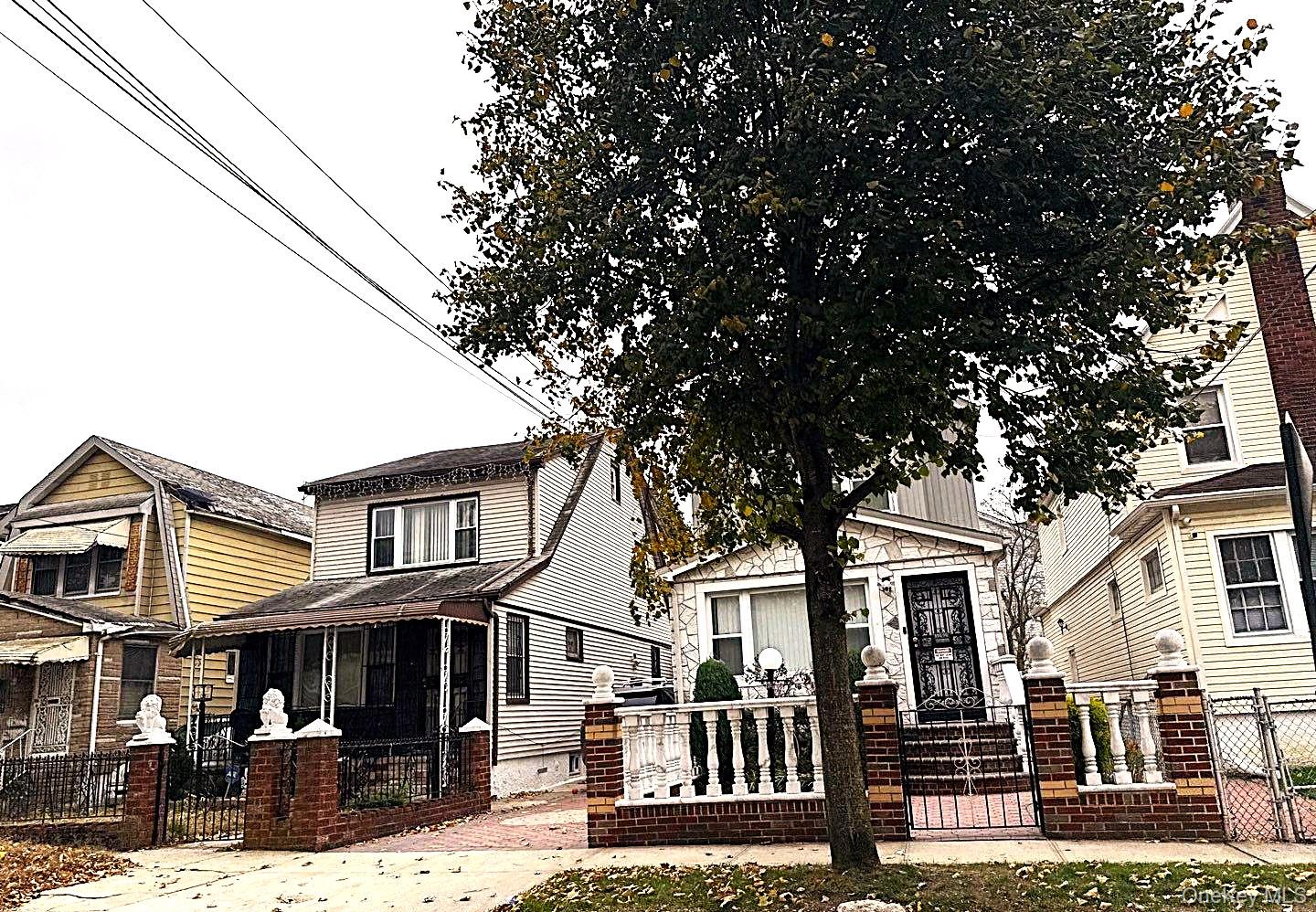 196-10 116th Avenue Queens, NY 11412 - Photo 2 of 4 a front view of a residential apartment building with a yard