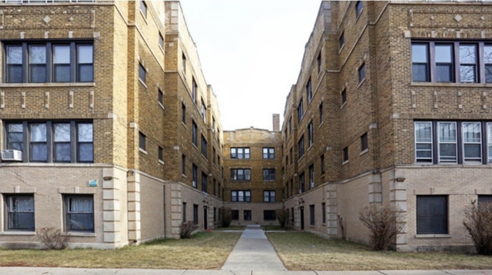 a view of a brick building next to a yard
