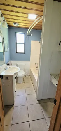 a bathroom with a sink a toilet and a window