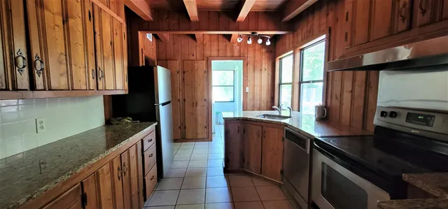 a kitchen with stainless steel appliances granite countertop a stove a sink and a microwave