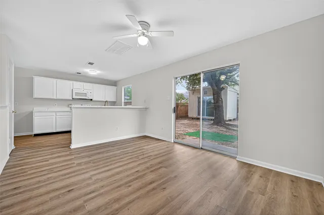 a view of a kitchen with a microwave and wooden floor