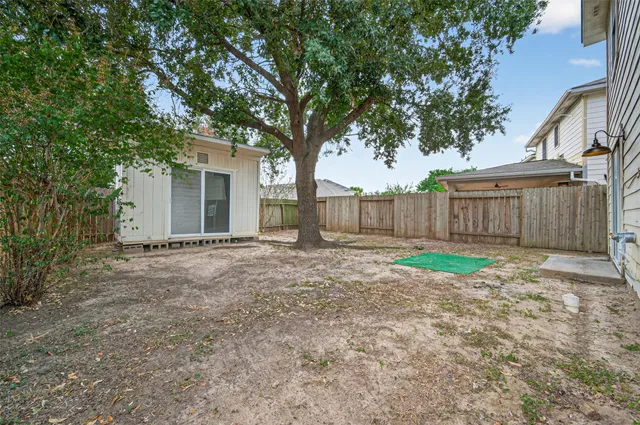 a view of a house with a yard and large tree