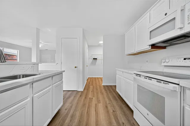a kitchen with white cabinets and white appliances