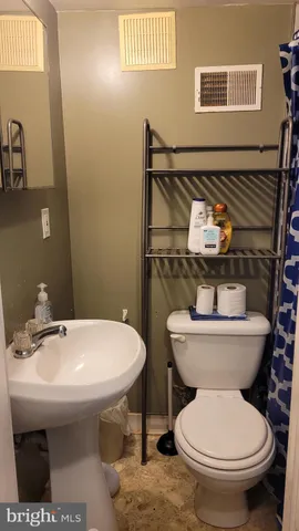 a bathroom with a toilet sink and mirror