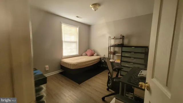 a bedroom with a bed and wooden floor