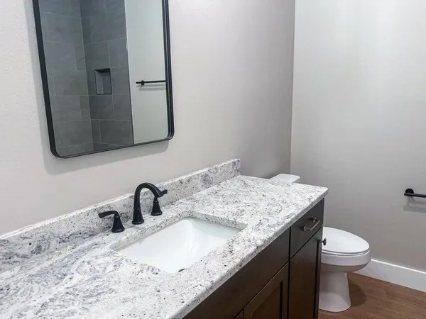 a bathroom with a granite countertop sink and a mirror