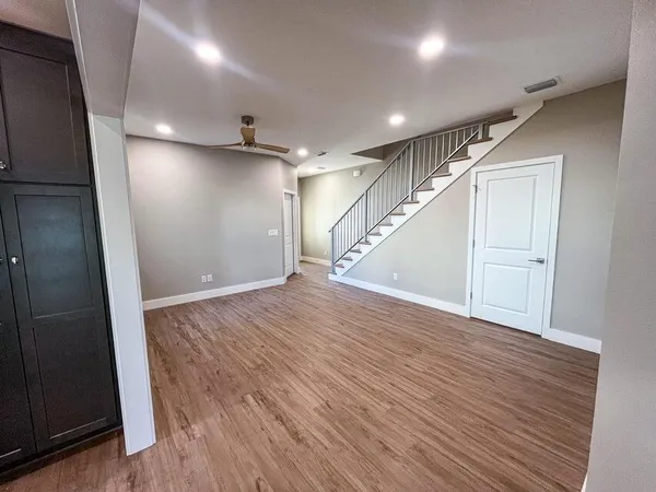an empty room with wooden floor and staircase
