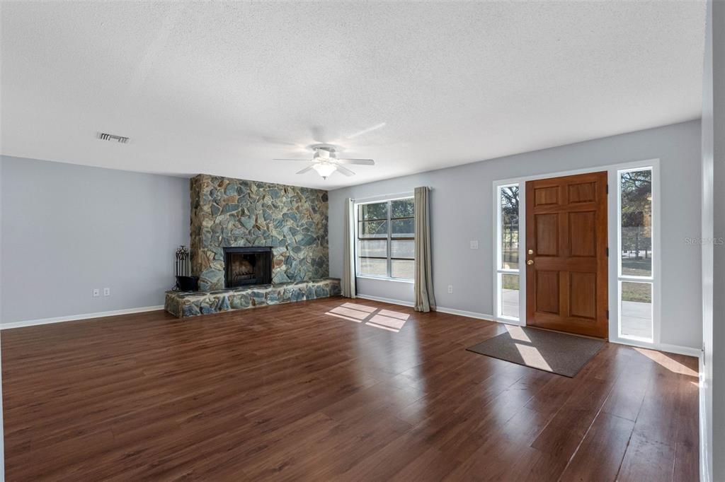 33237 Chancey Road Wesley Chapel, FL 33543 - Photo 5 of 59 an empty room with wooden floor fireplace and cabinet