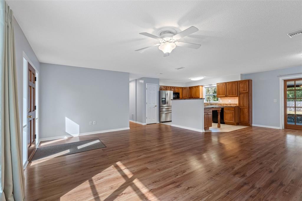 33237 Chancey Road Wesley Chapel, FL 33543 - Photo 8 of 59 a view of a livingroom with wooden floor and kitchen space