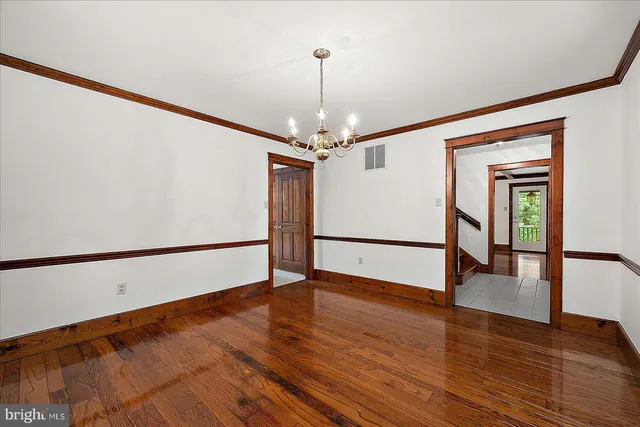 a view of a hallway with wooden floor and entryway