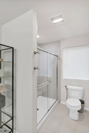 a bathroom with a toilet and a shower