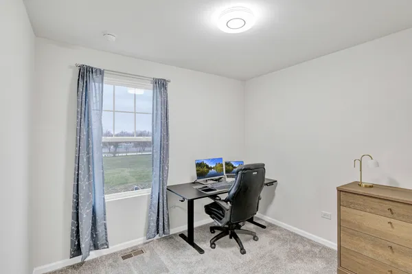 a view of a workspace with furniture and a window