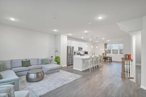 a living room with furniture and view of kitchen