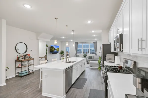 a large white kitchen with a large window and stainless steel appliances