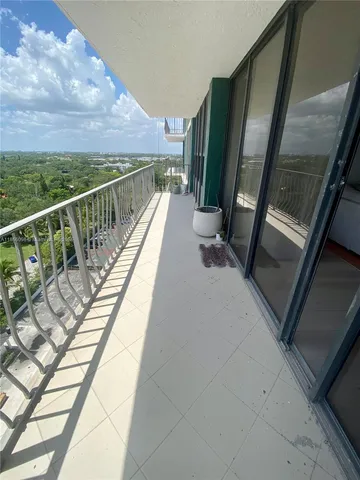 a living room with couches and kitchen view with wooden floor