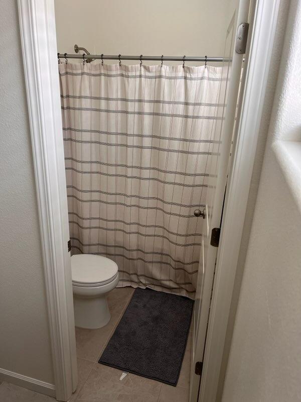 4106 Dennis Drive Clovis, CA 93619 - Photo 5 of 17 a bathroom with a toilet and a shower curtain
